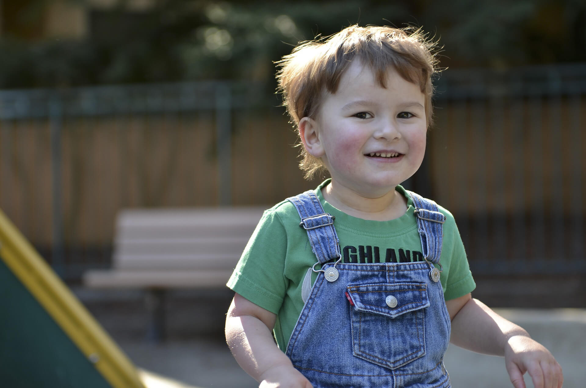 A young boy on the playground smiling
